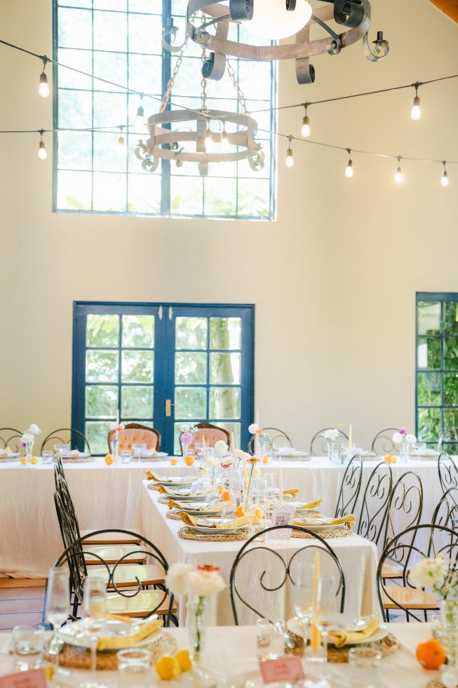 Bright indoor reception hall at Cossars Wineshed featuring double doors and hanging fairy lights.