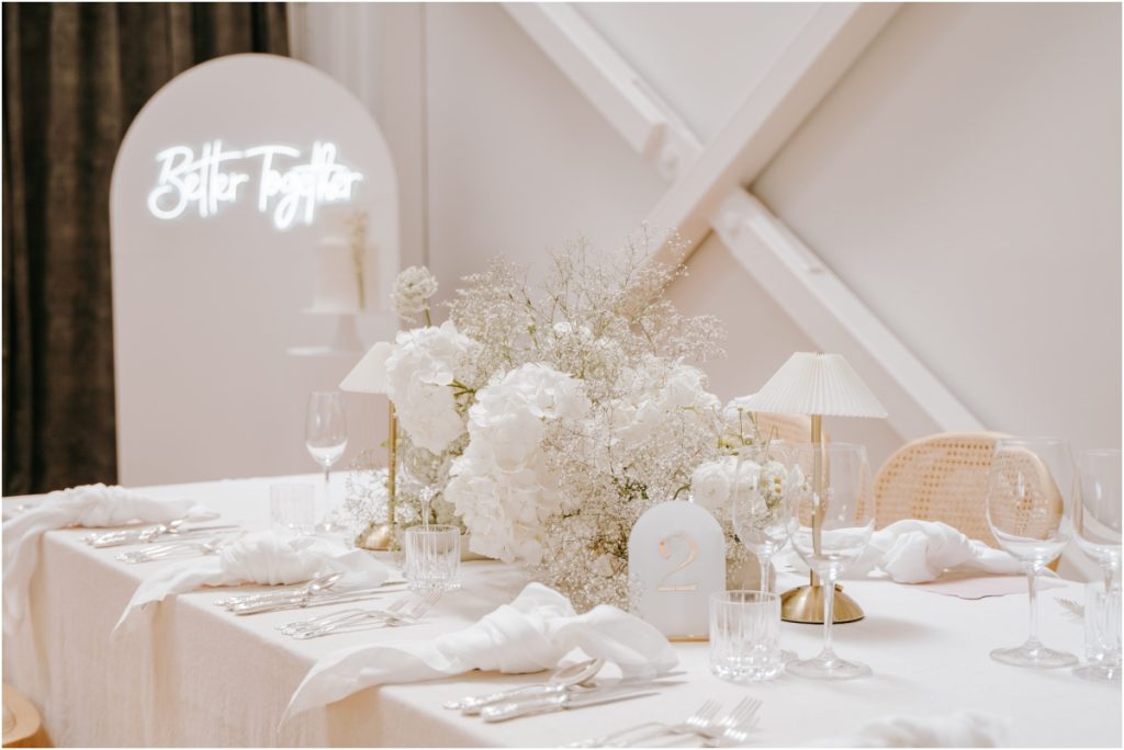 Modern white floral centerpiece and neon sign wedding styling by The Little Hire Company at The Welder Christchurch.