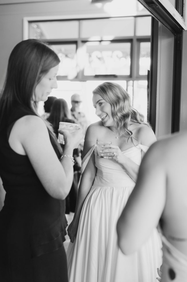 Candid black and white reception photography of wedding guests cheering