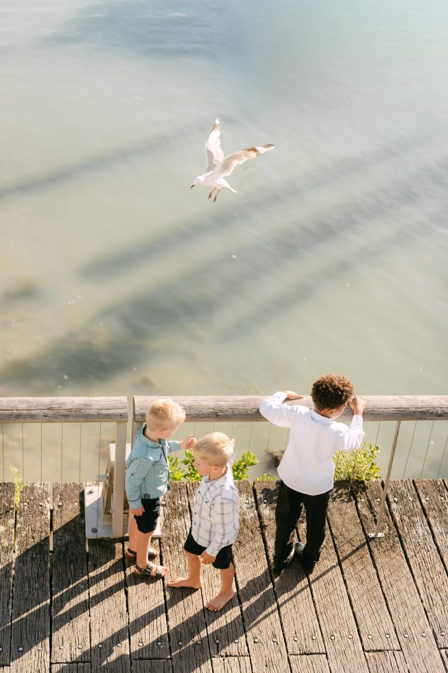 Documentary style wedding photography capturing children playing on a coastal jetty