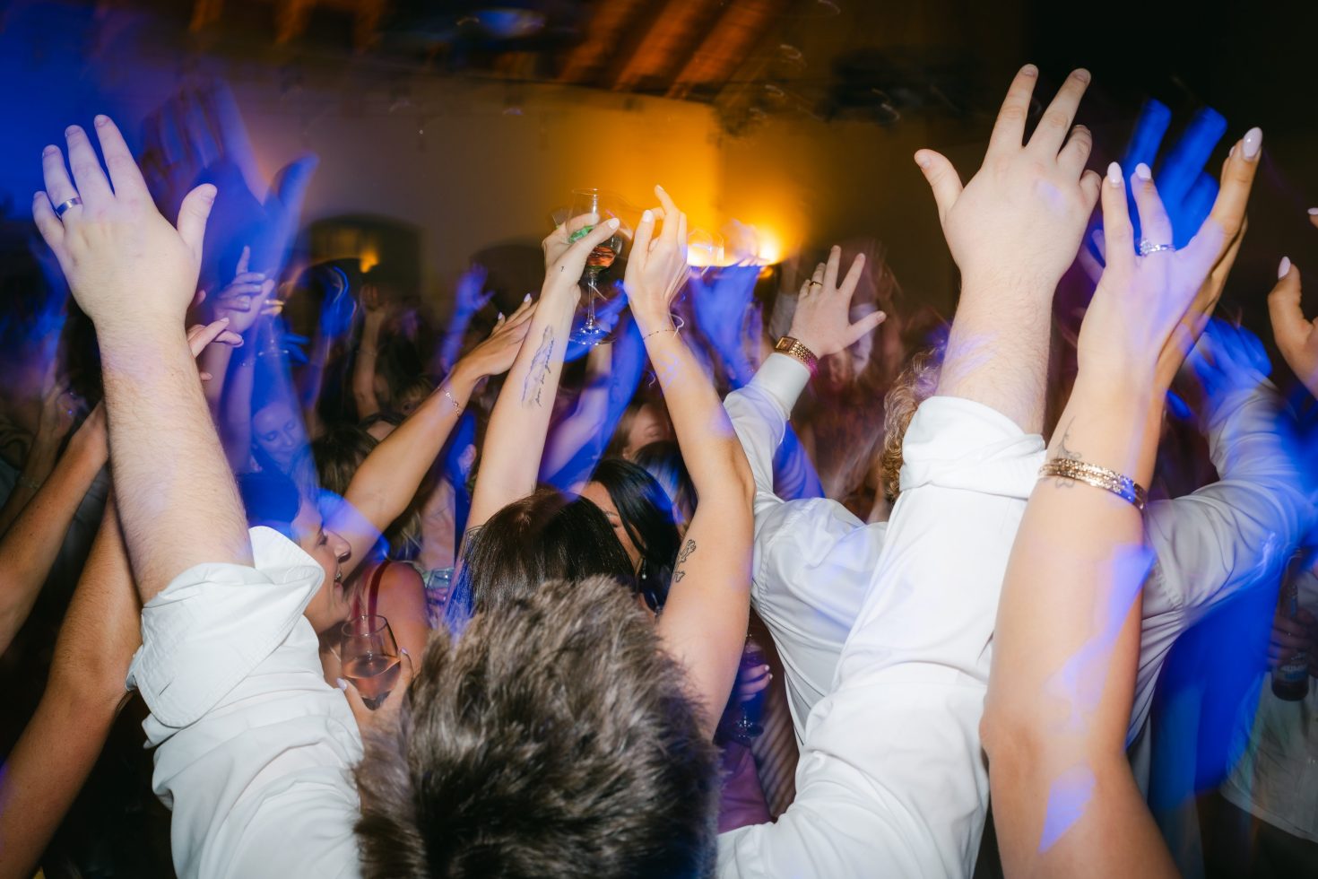 Christchurch wedding party guests dancing with hands raised.