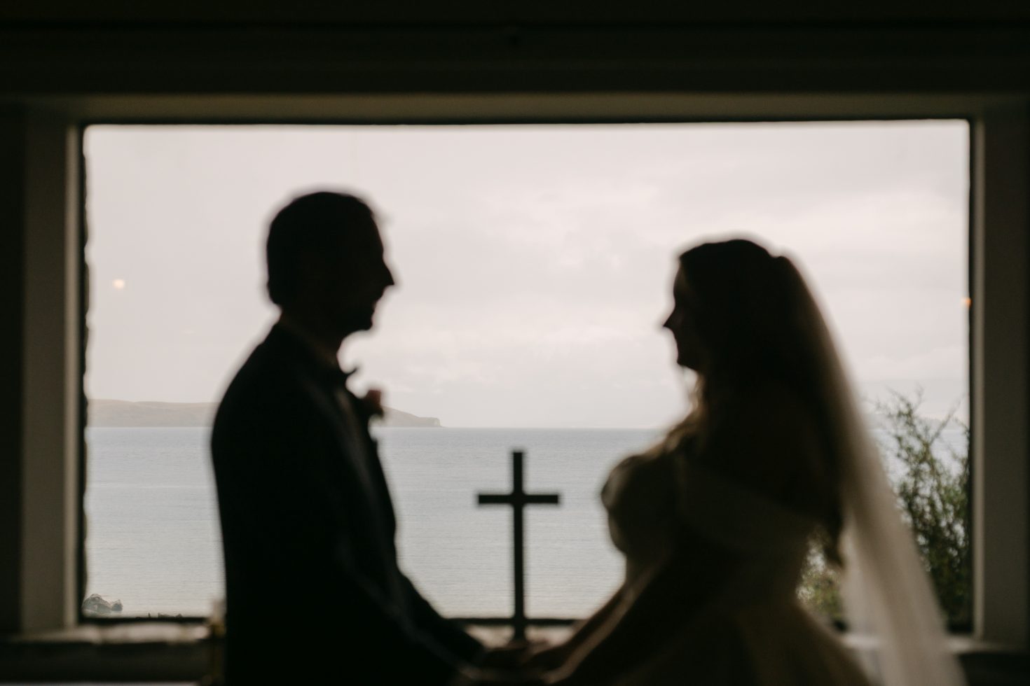 An artistic silhouette inside the chapel looking over the lake during a Church of the Good Shepherd wedding elopement.
