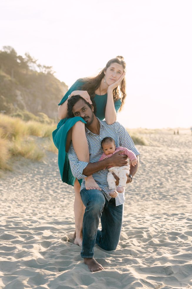 Candid family portrait photography in Christchurch: Parents playing with their baby on a scenic sandy beach by Agnes Grace Photo & Film.