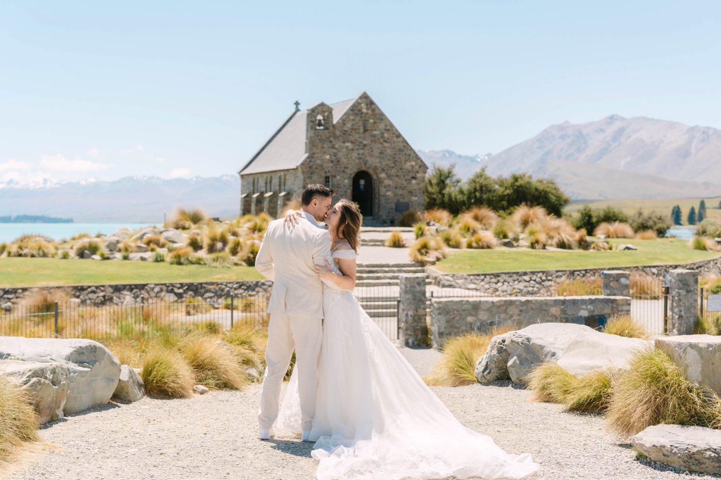 A bride and groom kissing on the path outside a romantic Church of the Good Shepherd wedding elopement.