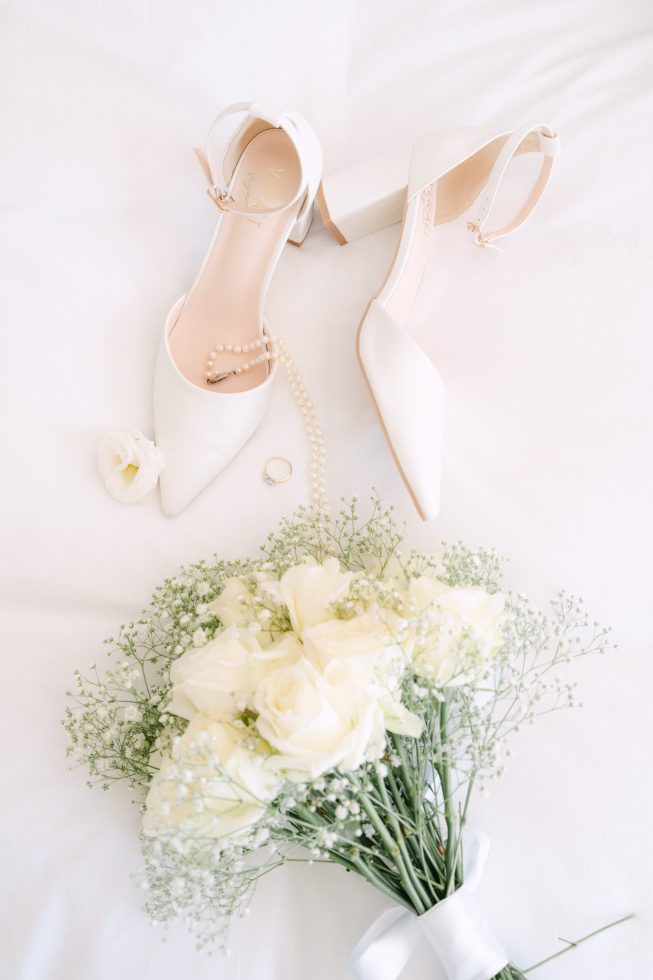 Bridal wedding details: Soft-focus close up of elegant white bridal heels and tulle accents by Agnes Grace Photo & Film.