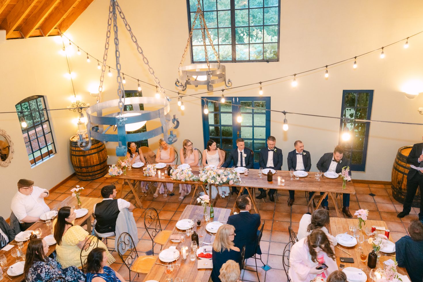ide angle view of guests seated inside the high-ceiling dining pavilion at a Cossars Wineshed wedding reception.