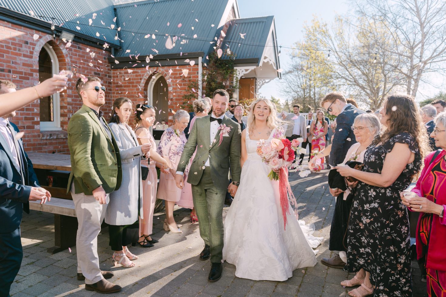 Guests throwing confetti as the bride and groom walk out of their Kingsdown Manor ceremony