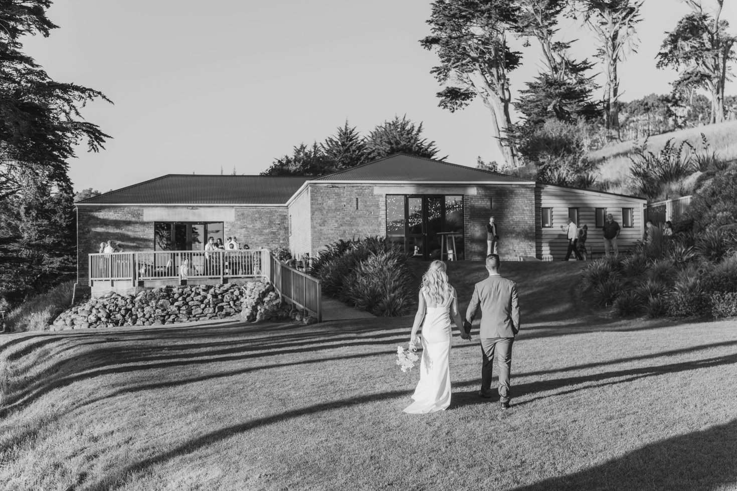 Black and white documentary couple portrait walking past the historic stone and brick walls of a country estate